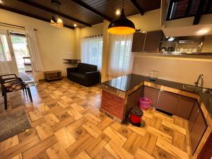 a kitchen and living room with a wooden floor at Zyamadhari in Mananthavady