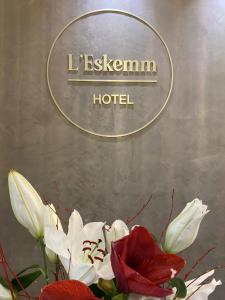 un jarrón con flores blancas y rojas delante de un hotel en Hotel Restaurant l'Eskemm St Brieuc-Trégueux, en Tregueux