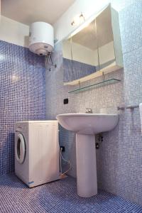 a bathroom with a sink and a toilet and a mirror at Appartamenti Marinelli - Santa Maria di Leuca in Leuca