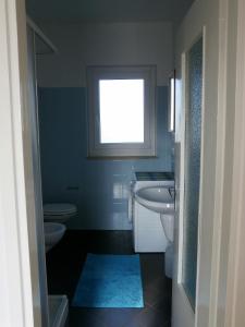 ein Bad mit 2 WCs, einem Waschbecken und einem Fenster in der Unterkunft Casamanax in Maccagno Inferiore