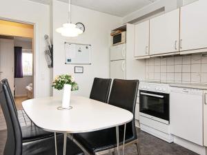 cocina con mesa blanca y sillas negras en Holiday home Højer XII, en Højer
