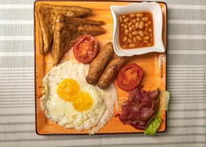 a plate of breakfast food with eggs bacon beans and toast at Gardens Executive Suites in Kikuyu