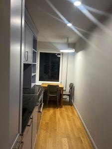 Una cocina con mesa y sillas y una ventana. en Sunrise Klaipedas apartments, en Liepāja