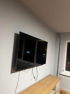 Un televisor de pantalla plana colgado en una pared en Sunrise Klaipedas apartments, en Liepāja
