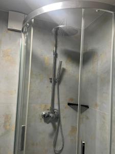 una ducha con cabezal de ducha en un baño en Sunrise Klaipedas apartments, en Liepāja