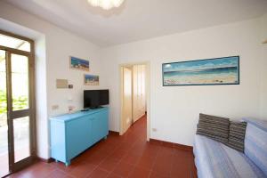 a living room with a blue cabinet and a television at Villa Aiali in Marina di Campo