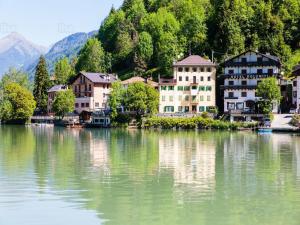 a group of buildings on the shore of a lake at Maison al Lago in Alleghe