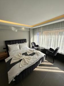 a bedroom with a large bed with chairs and a window at Torch Suit in Istanbul