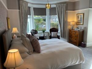 Un dormitorio con una gran cama blanca y una ventana en Brigstock House, en Llandudno