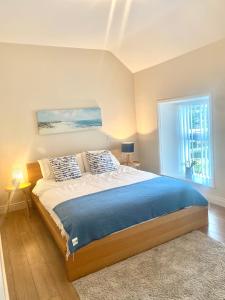 Un dormitorio con una cama grande y una ventana en Village Way Apartments, en Kincasslagh
