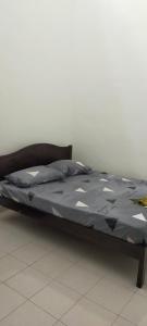 ein Bett mit blauer Decke darüber in der Unterkunft Kerian Putra Muslimstay in Parit Buntar