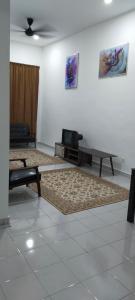 een woonkamer met een bank en een tafel bij Kerian Putra Muslimstay in Parit Buntar