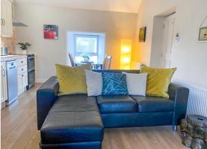 a living room with a blue couch with yellow pillows at Village Way Apartments in Kincasslagh