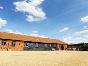 a brick building with a blue sky in the background at Archies Barn in Lenwade