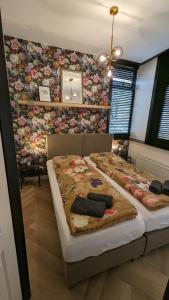 a bedroom with two beds and a floral wall at Heiligeweg 48 in Harlingen