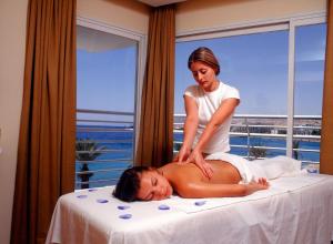 a woman is giving a woman a massage on a bed at Yuval holidey aprtment eilat in Eilat