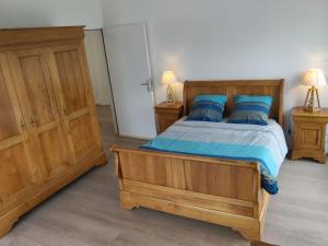 1 dormitorio con cama de madera y almohadas azules en Appartement au Crotoy, en Le Crotoy