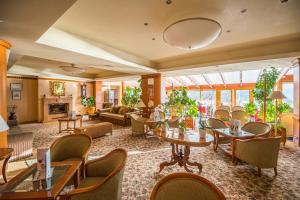 a lobby of a hotel with tables and chairs at Silvanus Hotel in Visegrád