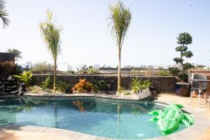 a swimming pool with a green turtle in the water at Villa Panoramica in Yaiza +21 photos