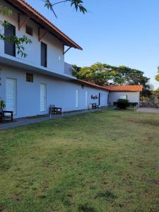 a building with a grass yard in front of it at Pousada Luz De Lua in São Pedro