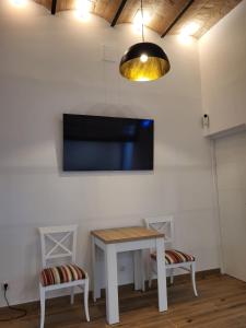 Habitación con mesa y TV en la pared. en Loft en Montjuic en Barcelona