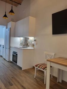 una cucina con armadi bianchi e un tavolo con una sedia di Loft en Montjuic a Barcellona