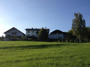 ein Grüngrasfeld mit Häusern im Hintergrund in der Unterkunft Landgasthof Peterbauer in Schärding