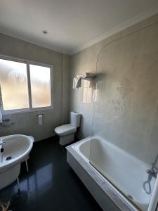 a bathroom with a sink and a tub and a toilet at San Luis in Vilaboa