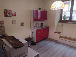 a kitchen with a red cabinet and a red counter at chey MYBAM, agréable maison au centre de Sélestat in Sélestat