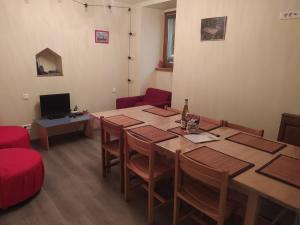 a dining room with a table and chairs and a television at chey MYBAM, agréable maison au centre de Sélestat in Sélestat