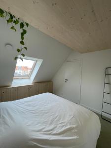 een slaapkamer met een wit bed en een raam bij Julie's appartement aan zee - JAAZ in Nieuwpoort