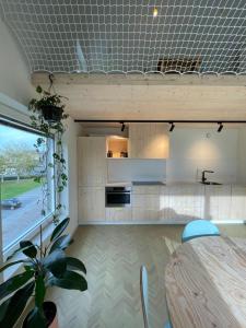 een keuken met een tafel en een groot raam bij Julie's appartement aan zee - JAAZ in Nieuwpoort