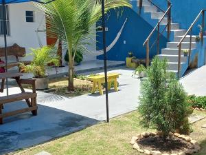 un patio con un tavolo giallo e palme di Hospedaria da Praia Fortaleza a Fortaleza