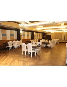 uma sala de jantar com mesas brancas e cadeiras brancas em Hotel Solista, Chittorgarh-312001, em Chittaurgarh