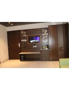 uma sala de estar com uma televisão na parede em Hotel Solista, Chittorgarh-312001, em Chittaurgarh
