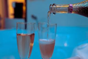 due bicchieri di champagne in cui viene versato di DolceVita Suite Boutique a Bologna
