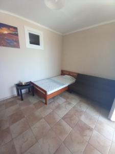 1 dormitorio con 1 cama y suelo de baldosa en Αξέχαστη εμπειρία με θέα την θάλασσα! en Paralia Dionysiou