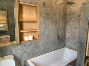 a bathroom with a tub and a toilet and a sink at Comfortable 2-Bedroom place with indoor Fireplace in Mossel Bay