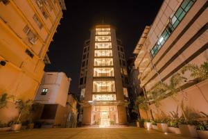 a tall building in a city at night at Marine Inn Hotel in Cochin