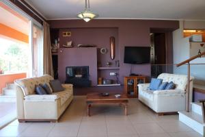 a living room with two couches and a tv at StarLight SeaView in Gouvia