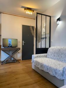 a living room with a bed and a television at Ollya in Paris