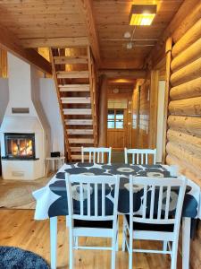 comedor con mesa, sillas y chimenea en Holiday Home Honkakoli 1 en Kolinkylä
