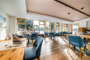 a dining room with tables and chairs and windows at Hotel Kristall-Saphir Superior in Saas-Almagell