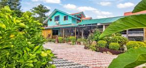 a house with a blue roof and a brick walkway at Bwaver Cottage in La Digue