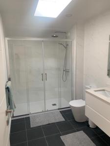 een badkamer met een douche, een toilet en een wastafel bij Peniche36 in Peniche
