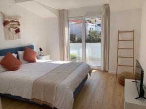 een slaapkamer met een bed en een groot raam bij Peniche36 in Peniche
