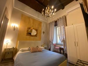 ナポリにあるCorso 211 Beds & Suitesのベッドルーム1室(大型ベッド1台、シャンデリア付)