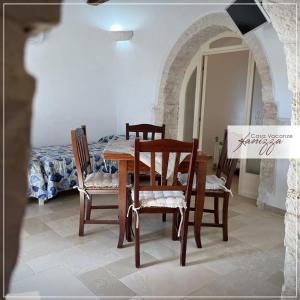 a dining room with a table and chairs and a bed at Trullo della Selva in Alberobello +14 photos