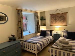 a bedroom with two beds and a window at Harbourside 2 Bed apartment, Barmouth Bridge Views in Barmouth