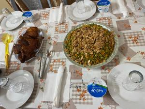 une table avec des assiettes de nourriture et un bol de noix dans l'établissement Reema's House, à Bayt Sāḩūr